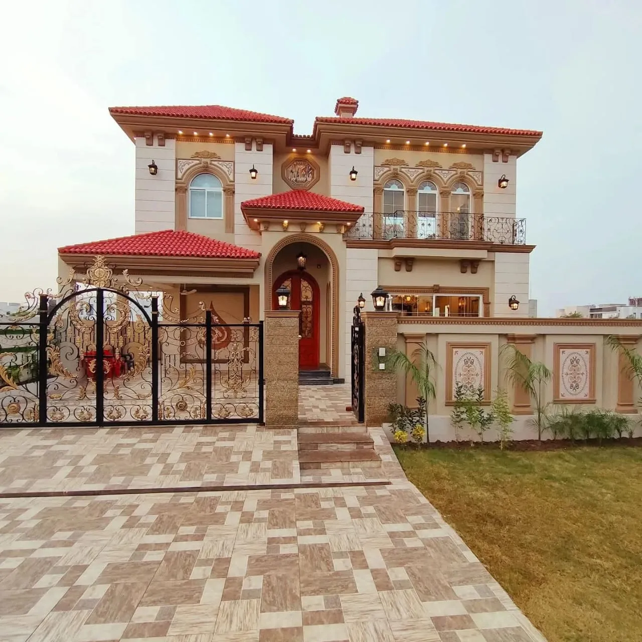 Completed traditional residence with a tiled roof, arched entrance and paved forecourt