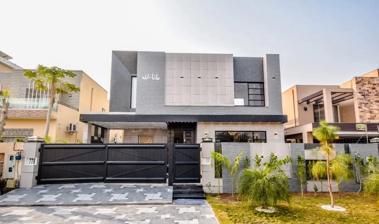 Street elevation of a completed contemporary house with dark metal gates and planting